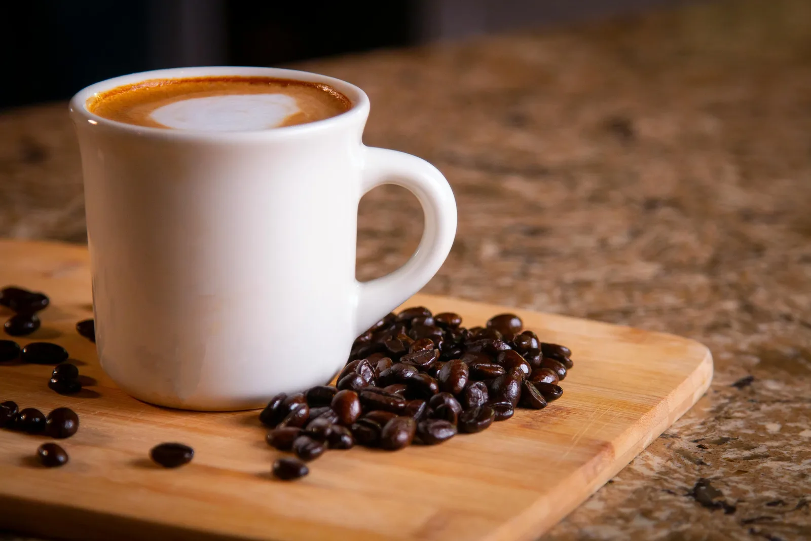 Overhead view of a fresh espresso on dark wood surrounded by coffee beans and a burlap sack, representing global coffee trade and specialty demand in 2026.