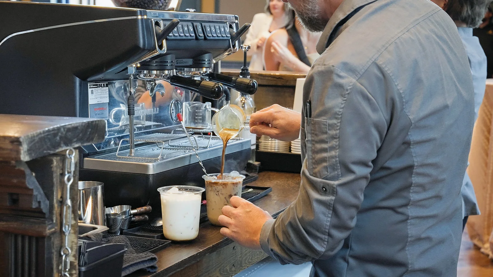 Barista pouring freshly pulled espresso into an iced drink at The Roaring Bean mobile espresso bar